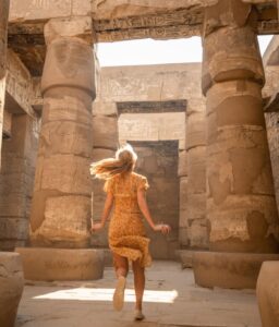 Woman runs inside ancient temple in Egypt, sunrise