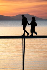 Two people quietly watching the sunset together, symbolizing presence and emotional connection.