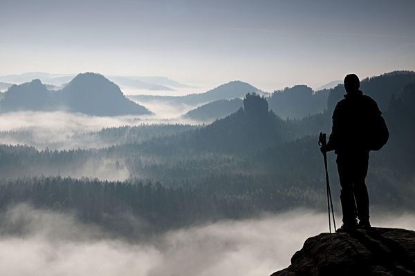Traveler reflecting on a mountain landscape, symbolizing spiritual awakening through sacred travel.